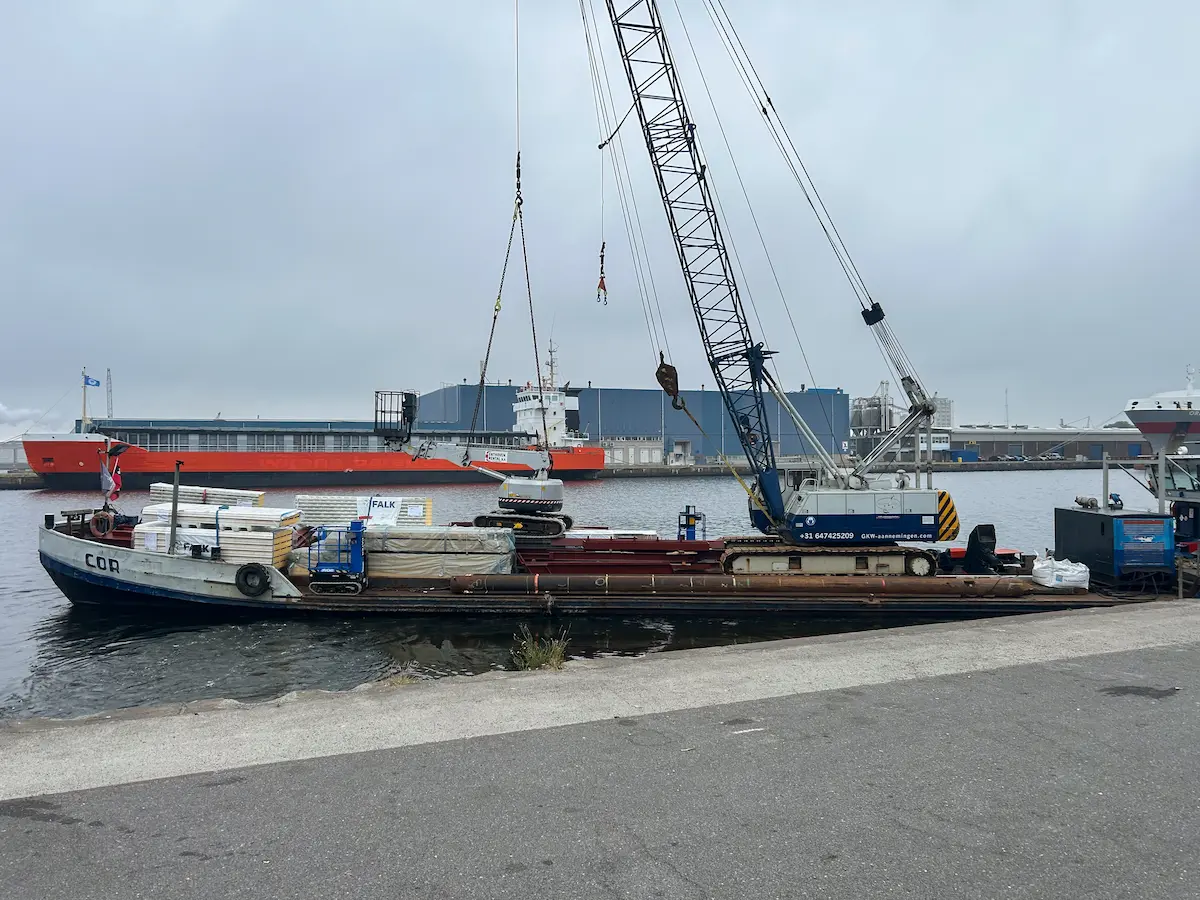 Transport van materialen voor de staalconstructie per boot in Amsterdam
