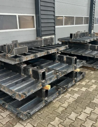 Afgeronde stalen frames voor tunnelbekisting Meerdere geproduceerde stalen frames voor tunnelbekisting staan klaar buiten de werkplaats